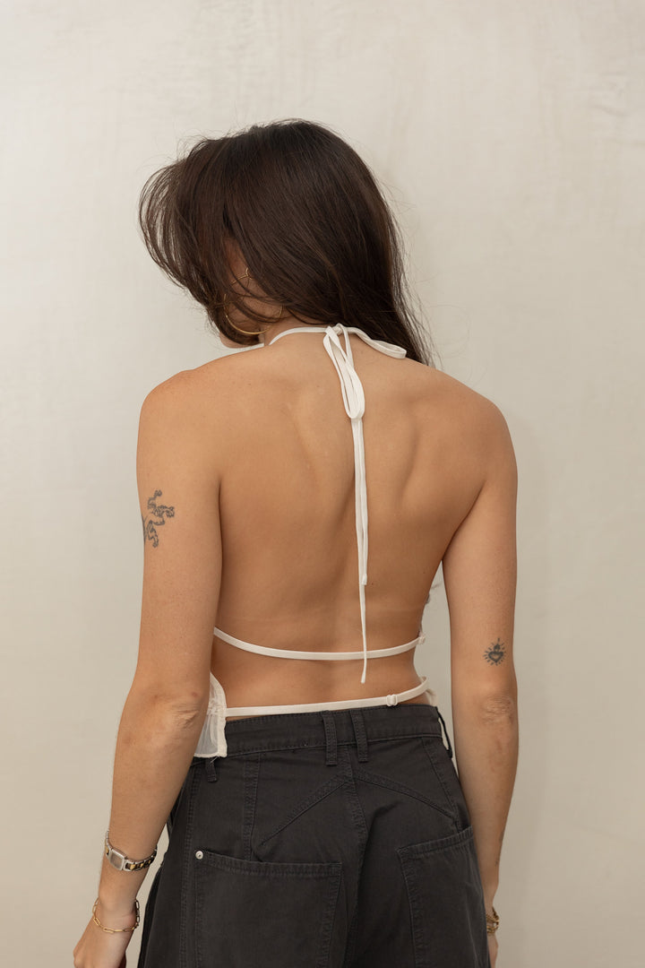 ISSUE 92 white halter neck boho chic top with tie back detail, sheer fabric, and ruffled hem.