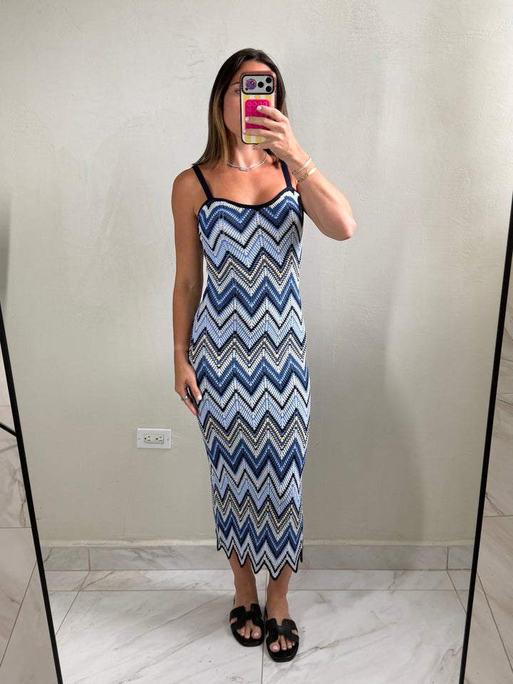 ISSUE 92 Ziggy Dress, a midi length knit dress with a blue, white, and yellow chevron pattern. Features spaghetti straps and a scalloped hem.